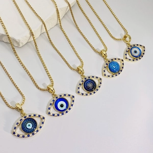 Set de cinco collares ojo turco bañados en oro con cristales azules sobre piedra blanca