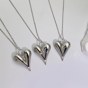 Polished silver heart pendant necklace in 18K plated copper on a white background