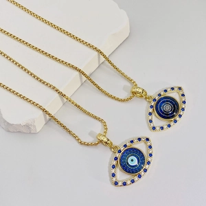 Detalle de collares de ojo turco chapados en oro con cristales azules sobre piedra blanca