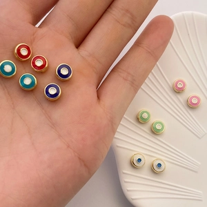 Detailansicht bunter Evil-Eye-Anhänger mit Goldrand für DIY-Schmuck in der Hand gehalten