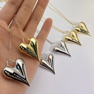 Detail of 18K gold and silver plated 3D heart pendants on delicate link chains