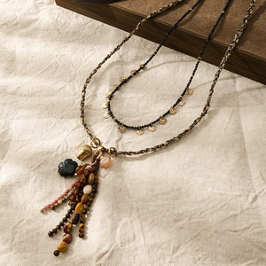 Dettaglio collana lunga boho vintage multistrato con nappa in pietra naturale e pigna