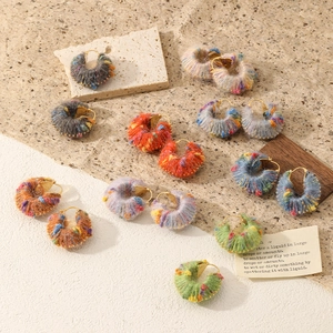 Detailed close-up of colorful handmade knitted wool yarn wrap C-shaped hoop earrings