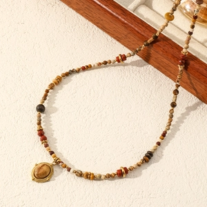 Detail of bohemian natural stone beaded necklace with sunset jasper and gold spacer beads