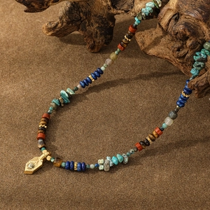 Nahaufnahme der Boho-Perlenkette mit Tigerauge, Türkis und goldenem Sonnenanhänger