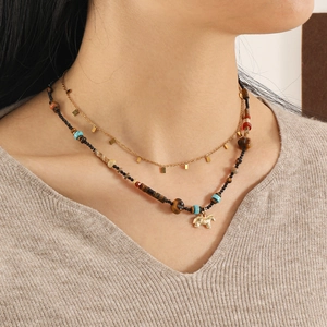 Detail einer Boho-Halskette mit Tigerauge-Perlen und goldenem Elefanten-Anhänger