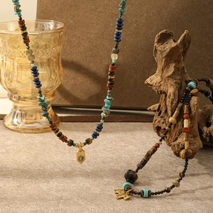 Nahaufnahme von Vintage-Perlenketten mit Tigerauge, Türkis und goldenen Anhängern