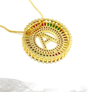 Nahaufnahme von goldenem A-Anhänger mit bunten Zirkonsteinen an einer feinen Kette