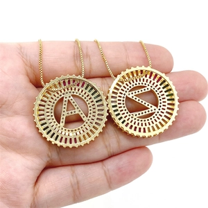 Detailaufnahme goldener Halsketten mit bunten Zirkonia-Buchstabenanhängern