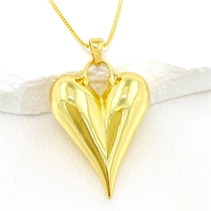 Vista detallada de un colgante de corazón 3D dorado con facetas verticales y cadena box