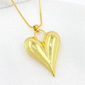 Detalle de un colgante de corazón 3D dorado pulido con una cadena de eslabones tipo caja