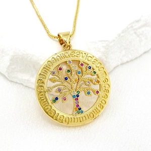 Golden Tree of Life necklace with colorful cubic zirconia stones on white fabric