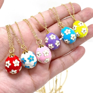 Detailed close-up of six colorful enamel Easter egg pendants with small flower patterns