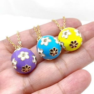 Close-up of enamel Easter egg pendants with floral patterns in blue, yellow, and purple