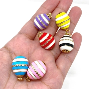 Close-up of six colorful 14K gold-plated enamel Easter egg pendants with zircon stripes