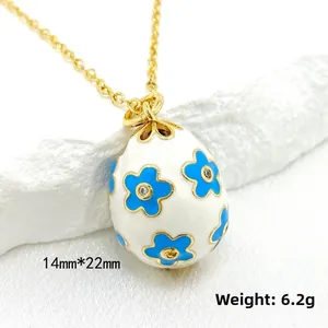 Detailed view of 14K gold enamel egg pendant with blue flowers and size 14mmx22mm