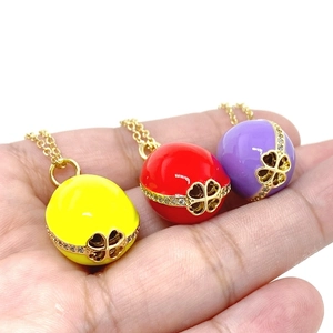 Detailed view of 14K gold plated Easter egg pendants with enamel finish and zircon stones