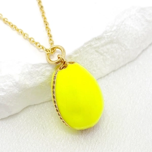 Macro shot of 14K gold-plated Easter egg pendant with vibrant yellow enamel and zircon stones