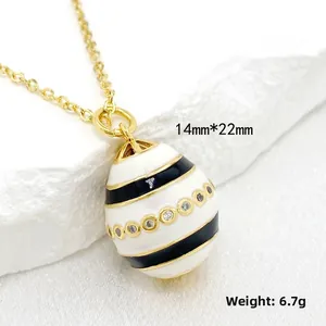 Detail view of 14K gold Easter egg pendant with enamel stripes and cubic zirconia