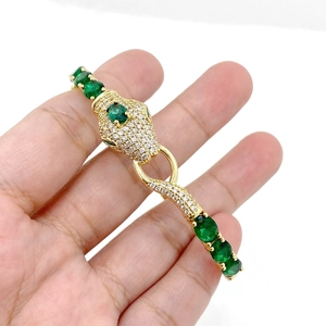 Vista detallada del brazalete de cabeza de serpiente chapado en oro con circonitas y gemas