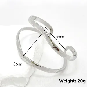 Detail view of silver hollowed cuff bracelet with hand-hammered texture on white stone