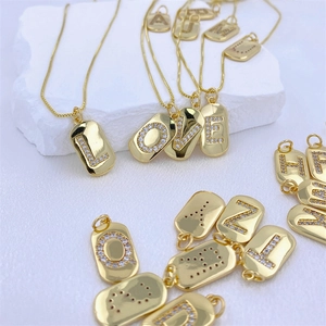 Collana minimalista dorata con ciondolo ovale a lettera e zirconi su seta bianca