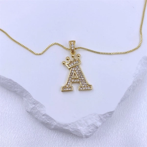 Vue détaillée du pendentif lettre A dorée avec couronne sertie de zircons sur chaîne box