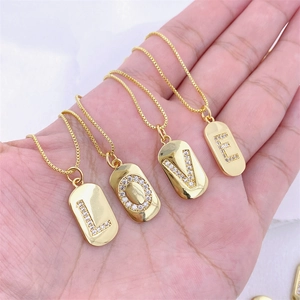 Collane minimaliste placcate oro con ciondoli LOVE in zircone tenute in mano