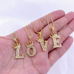 Détail de pendentifs lettres L O V E en or hip hop avec couronnes serties de zircons