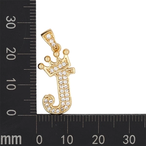 Photo macro du pendentif couronne lettre J plaqué or avec zircons et règle de mesure
