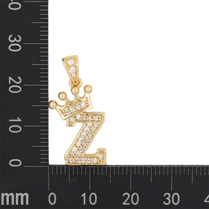 Vue macro du pendentif couronne lettre Z doré avec zircone cubique et règle de mesure