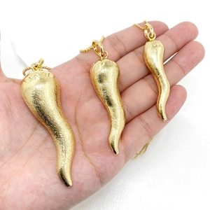 Dettaglio di tre dimensioni di collane con ciondolo a cornicello in oro spazzolato