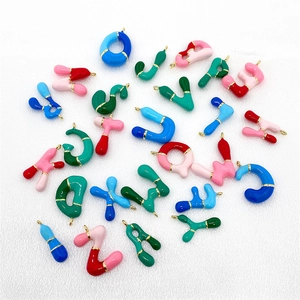 Macro view of colorful 26 enamel alphabet bubble pendants with gold-plated DIY loops