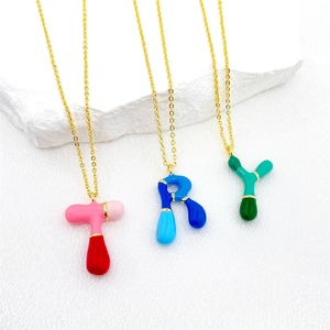 Detailed shot of colorful enamel bubble letter pendants T, R, and Y on gold chains