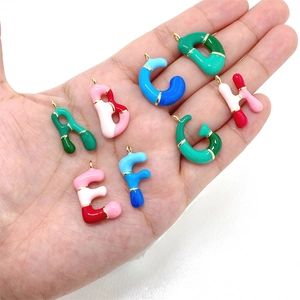 Macro view of colorful 3D bubble initial pendants in bright enamel and metal plating