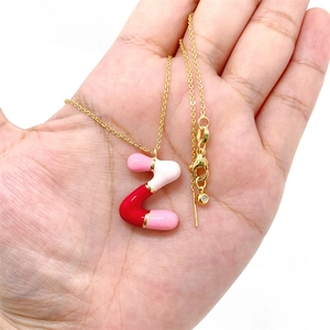 Macro detail of bubble letter Z pendant with colorful enamel inlay on a gold chain