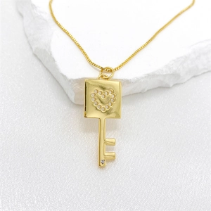 Collar de llave dorada con corazón hueco y colgante de circón sobre base de piedra