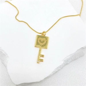 Elegante collar dorado con colgante de llave de corazón y circón en mármol blanco
