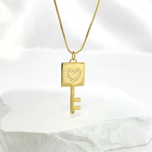 Collar con colgante de llave dorada con diseño de corazón calado y piedra de circón