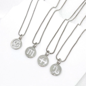 Detail view of silver hollow constellation pendants featuring Cancer and Scorpio signs