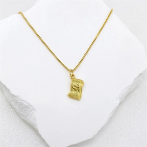 Minimalistischer goldener Dollarzeichen-Anhänger mit quadratischer Gliederkette auf Stein