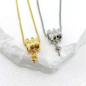 Gedetailleerde macro-opname van cilindrische hangerbases in goud en zilver voor DIY-sieraden