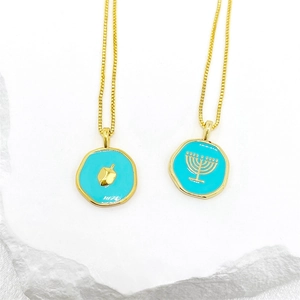 Détail de pendentifs en émail bleu avec Dreidel et Menorah dorés sur des maillons carrés