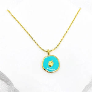 Gros plan détaillé d'un collier doré avec un pendentif irrégulier en émail bleu vif