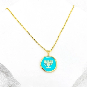 Vue macro d'un pendentif en émail bleu ciel avec une Ménorah dorée sur une chaîne