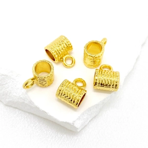 Lot de cinq pendentifs cylindriques plaqués or avec motif texturé à chevrons