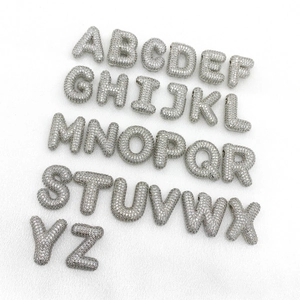 Macro detail of silver bubble alphabet pendants with full cubic zirconia stones for DIY jewelry