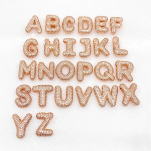 Detailed set of 26 rose gold bubble letters with pavé zircon stones on white silk