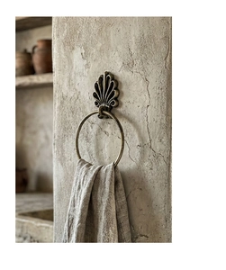 Detail of vintage shell relief cast iron towel ring with rustic bronze finish and linen cloth