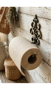 Detailed view of vintage bronze fleur-de-lis cast iron wall mounted paper towel holder